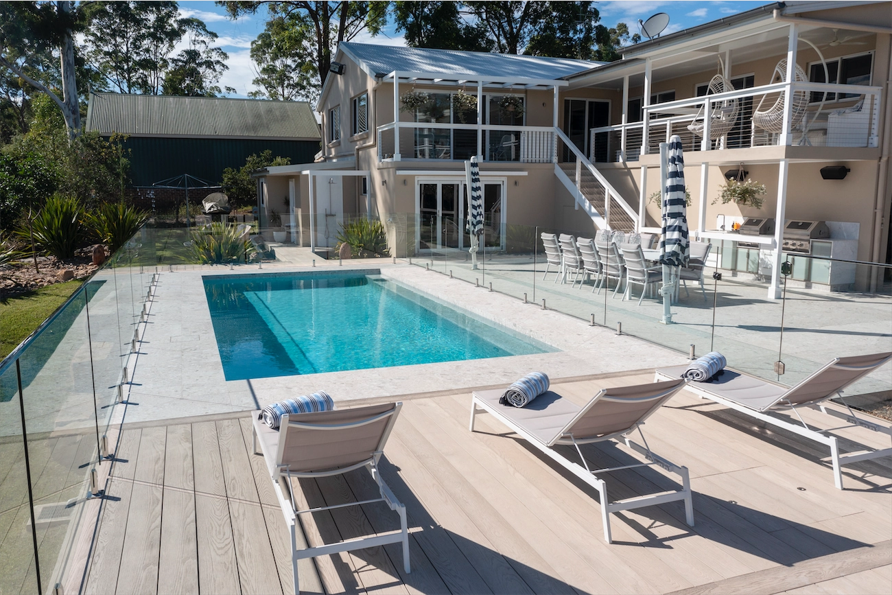 Frameless glass pool fence around a deck pool and house at a Kenthurst residence
