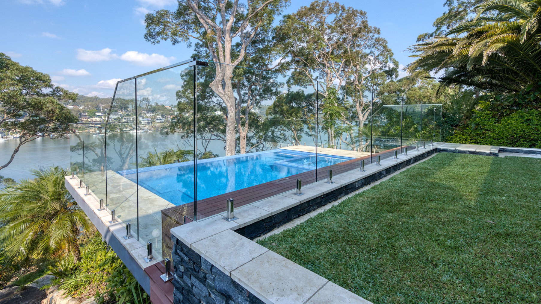 Frameless glass pool fence on a lawn terrace above the Georges River at an Oatley residence