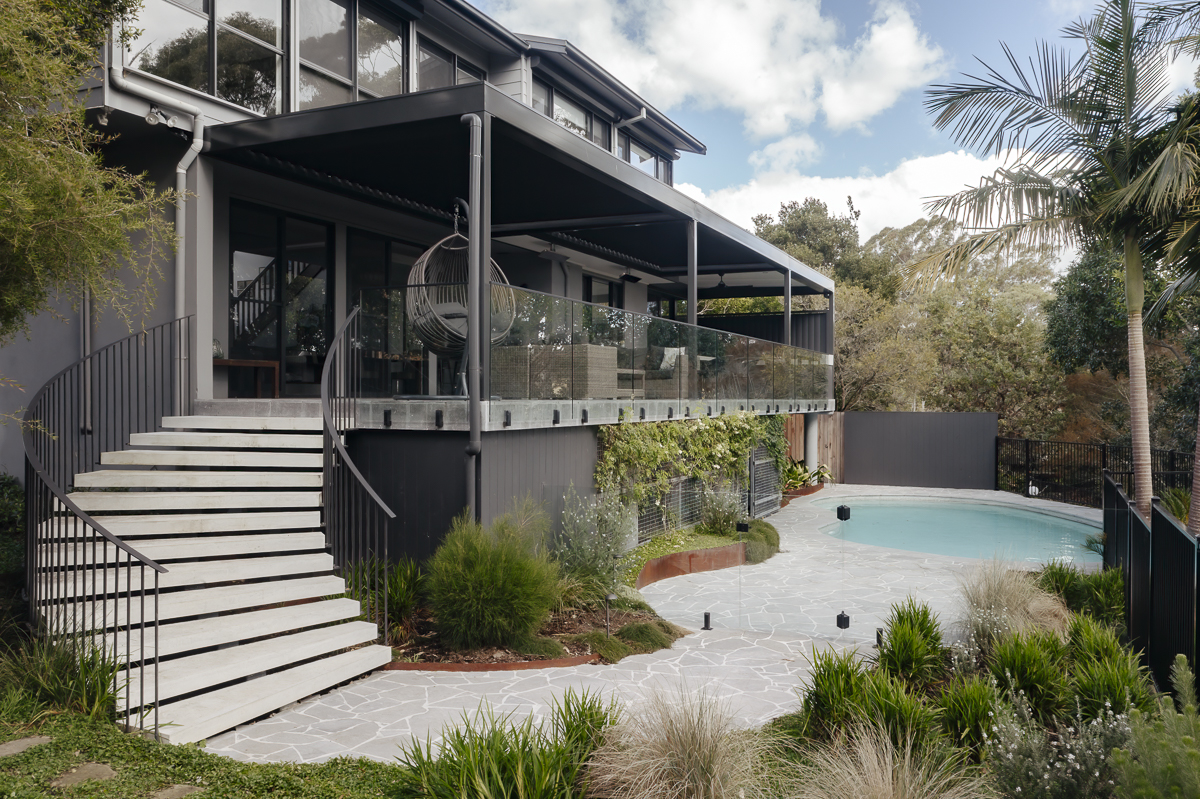 Frameless glass pool fence and balustrade below a modern two-storey home at a Killara residence
