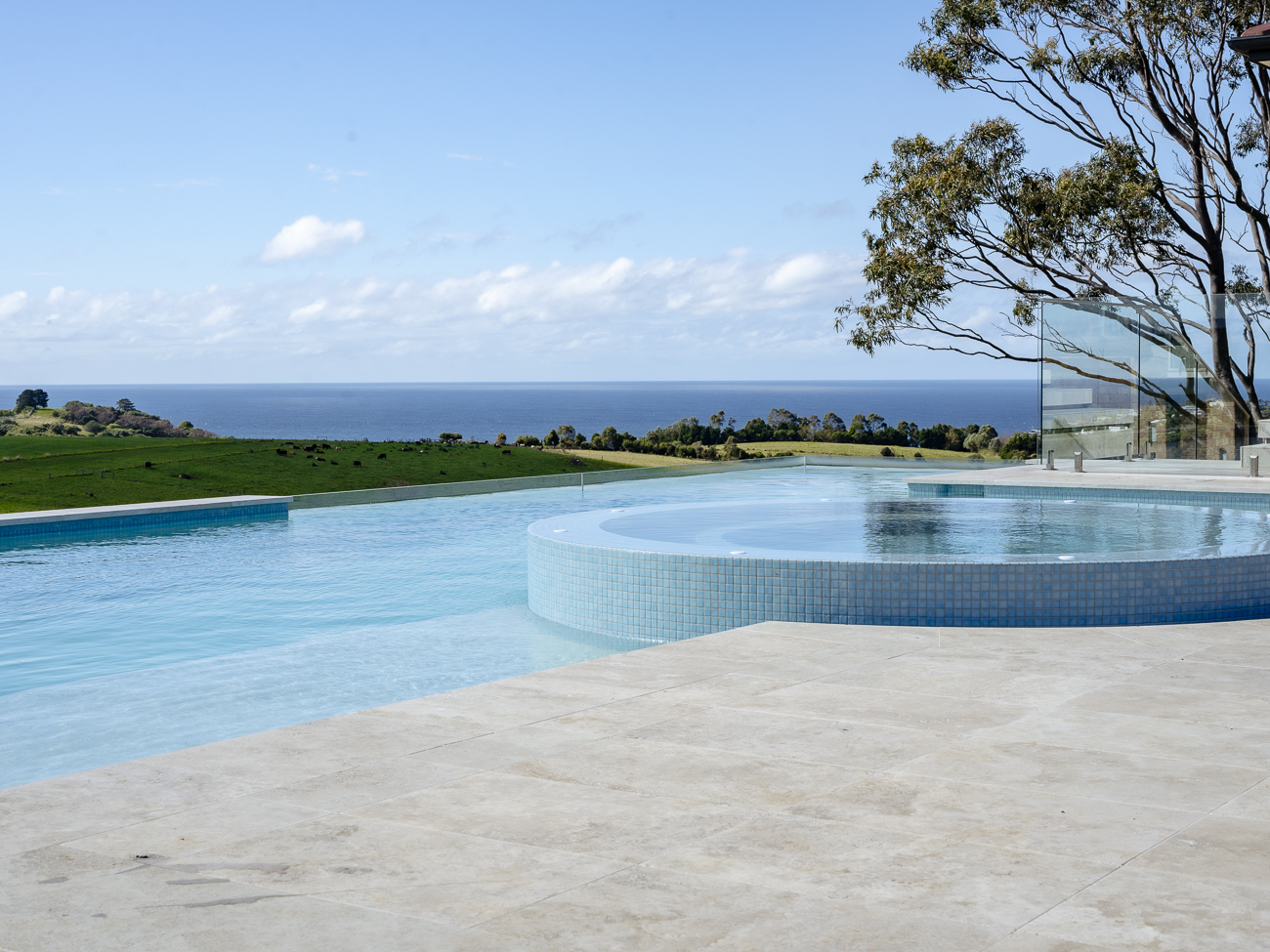Frameless glass pool fence around an infinity pool looking out to the ocean at a Kiama residence