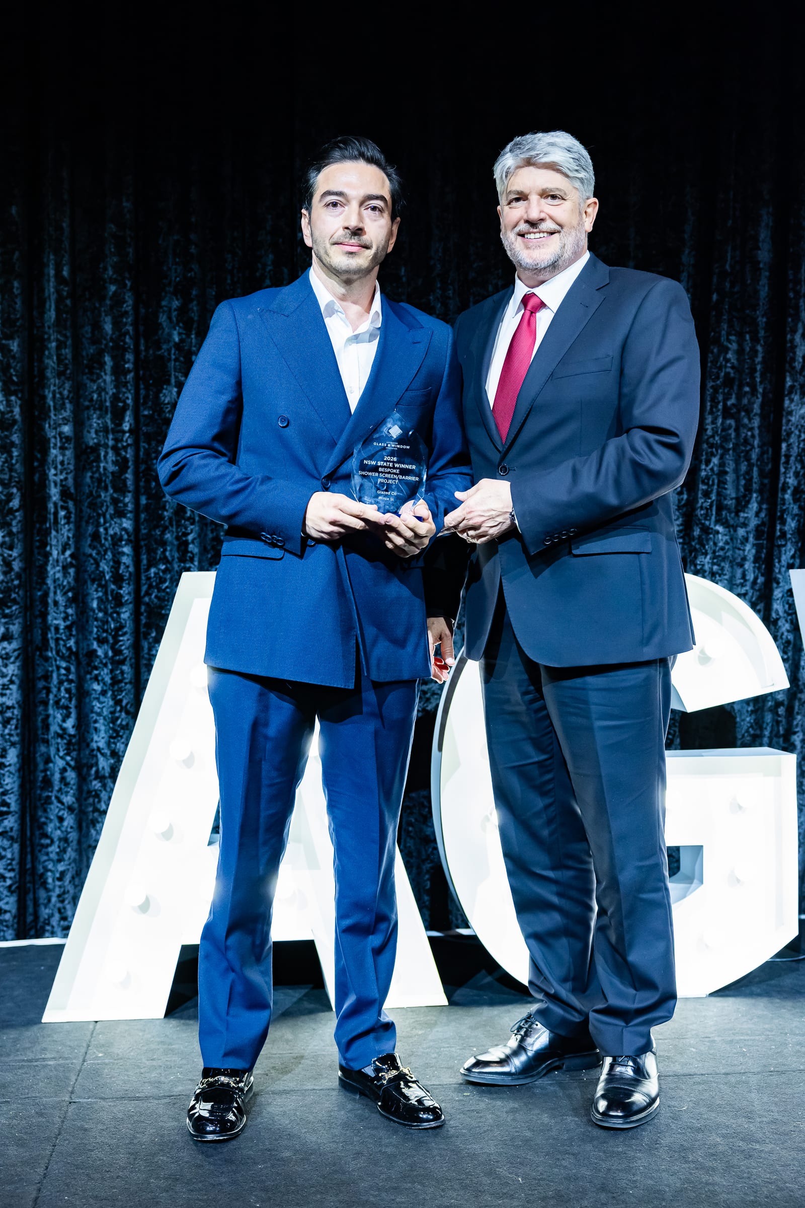 Daniel Chamoun of Glazed Co. receiving the 2026 AGWA NSW State Winner award for Bespoke Shower Screen/Barrier Project.